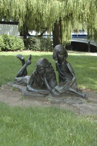 Alice and her sister, reading, as depicted in Alice in Wonderland, the novel by Lewis Carroll.